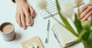 デスクで作業しながら日々の支出を整えるためのメモやアイデアを書き留めている様子